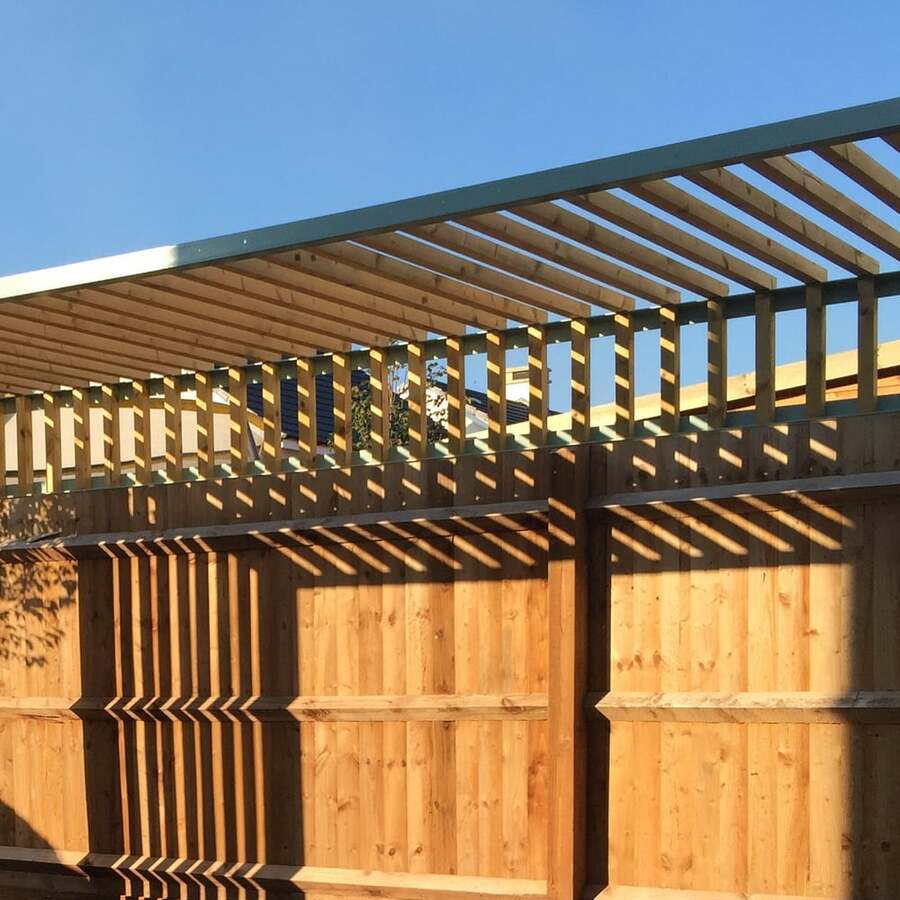 Close-up of timber pergola rafters and screen battens casting shadows